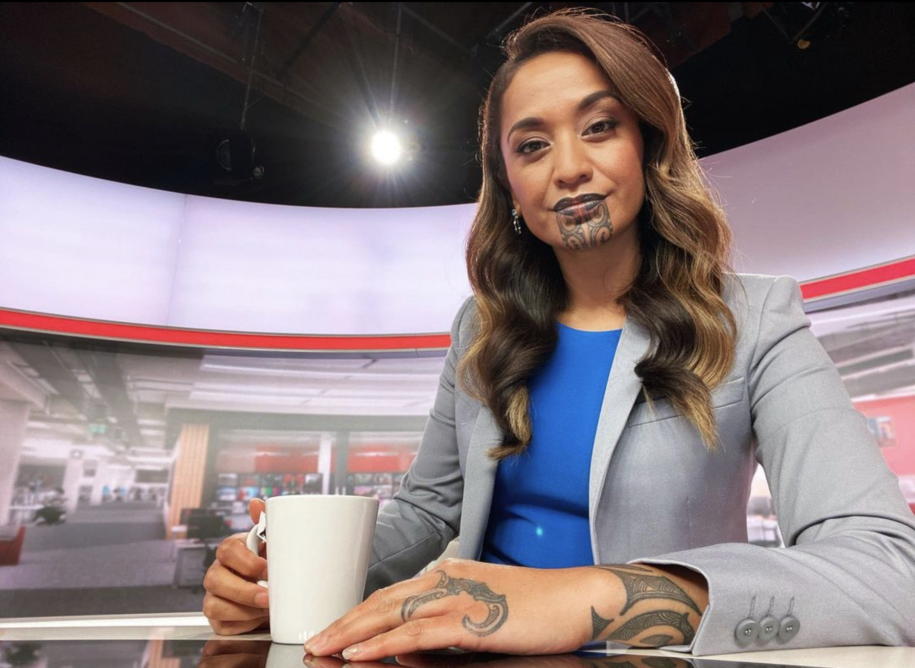 Newshub Live 430 presenter Oriini Kapaira takes a picture in her newsroom, making history as the first person to present news with a Māori tattoo.